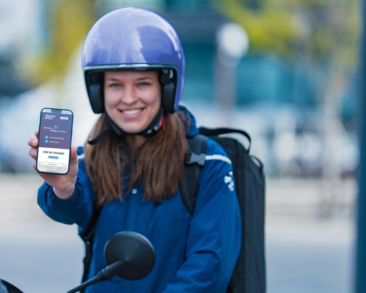 Jonge maaltijdbezorger toont de online veiligheidstraining op haar telefoon.