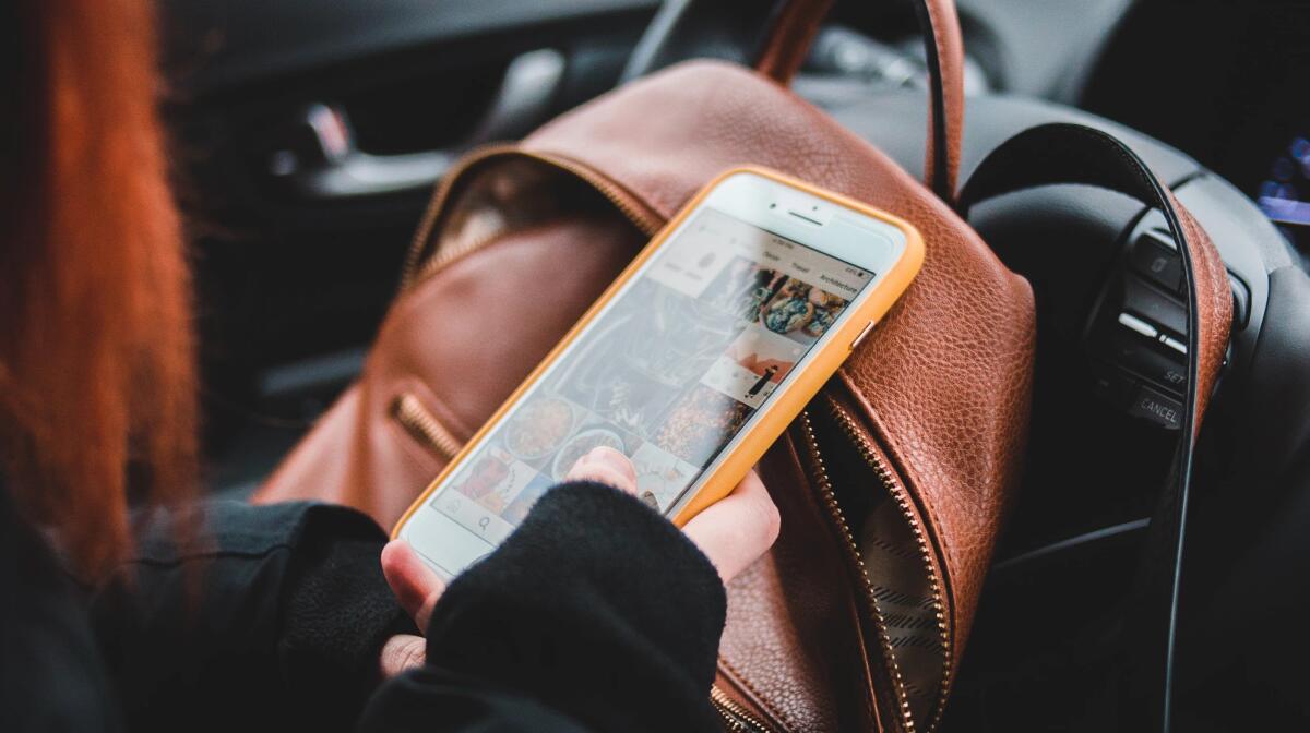 Vrouw met mobiele telefoon achter het stuur