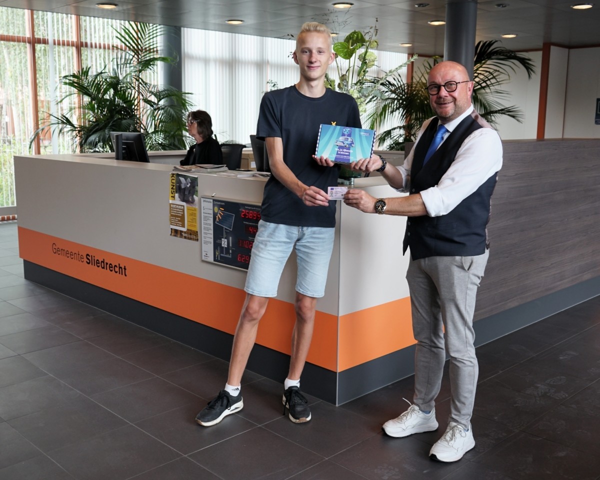 Wethouder overhandigt boxje aan jongere
