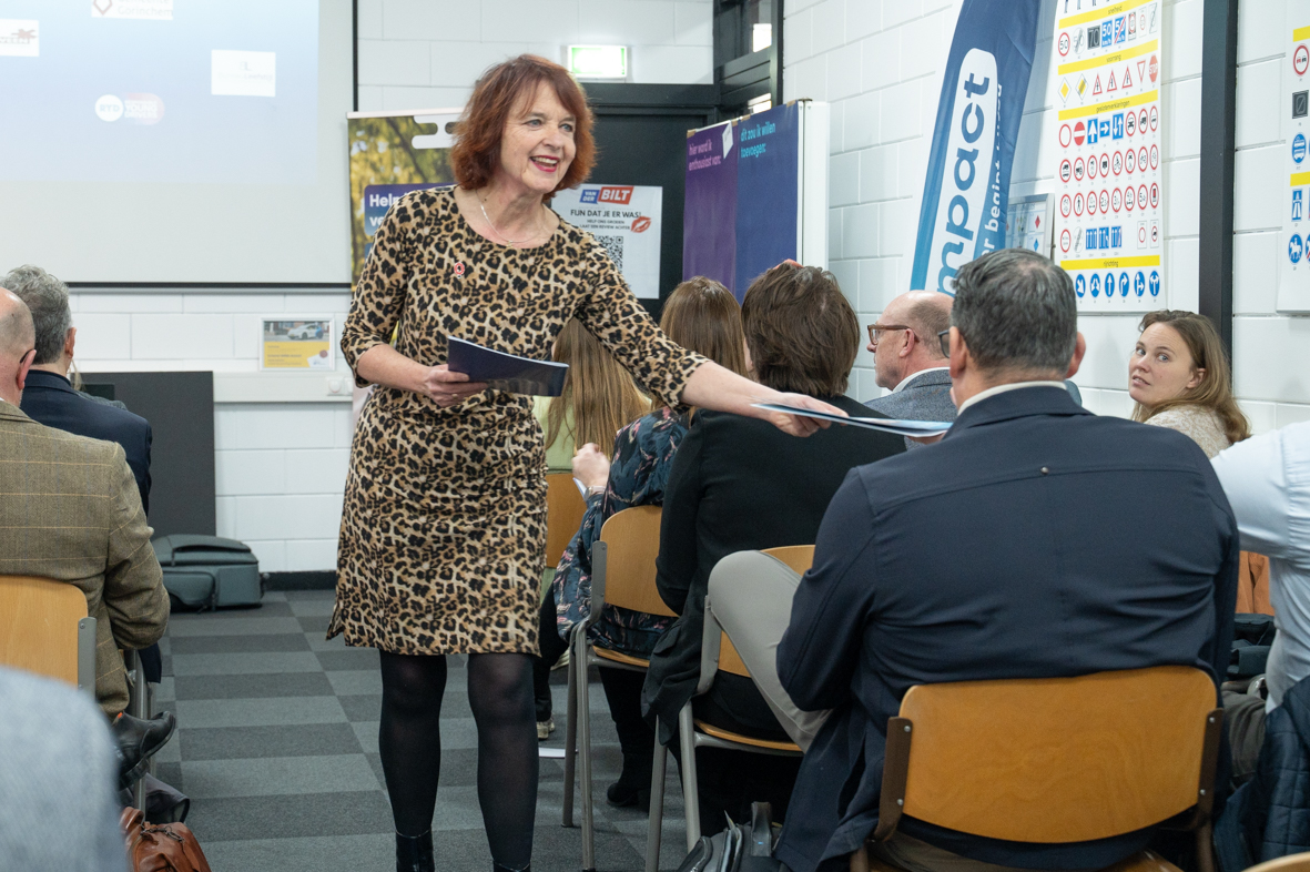Ada Aalbrecht overhandigt het handboek Young Drivers Experience aan een van de organisatoren