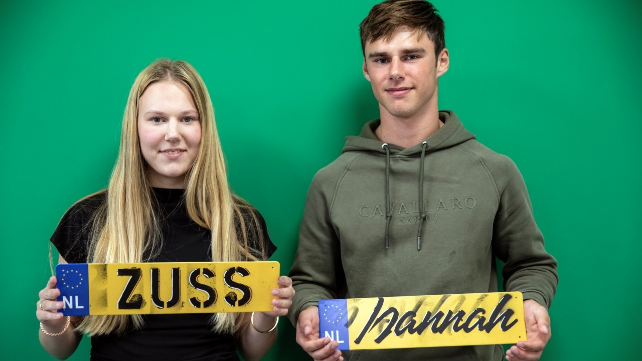 Twee deelnemers met hun van graffiti voorziene kentekenplaat
