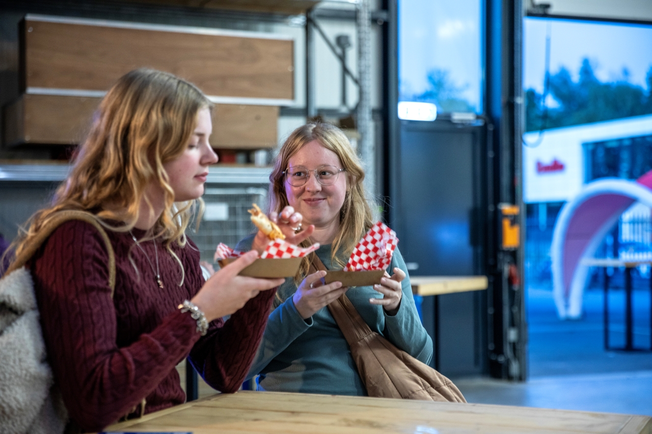 Twee deelnemers genieten van de snacks