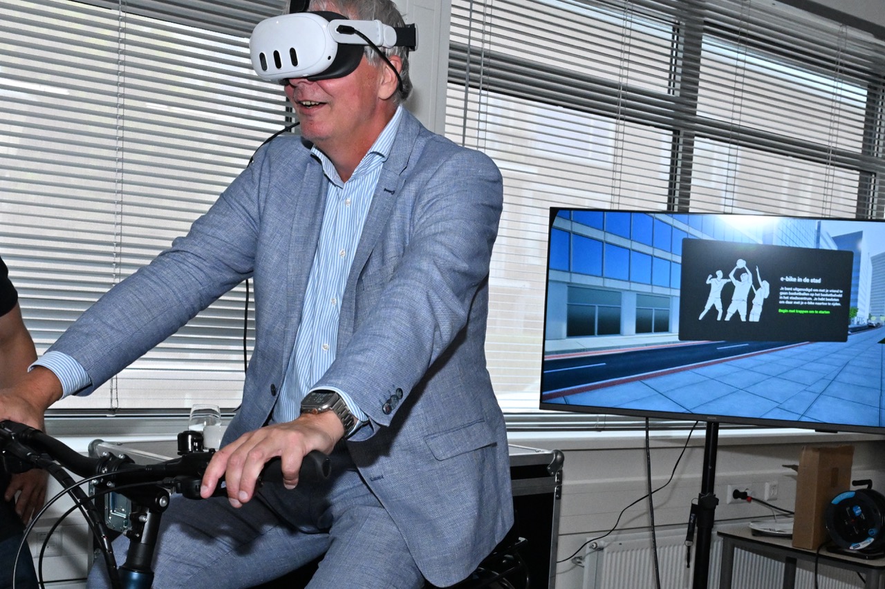 Een deelnemer met VR-bril op de e-bike simulator